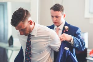 Groom putting on his formal coat
