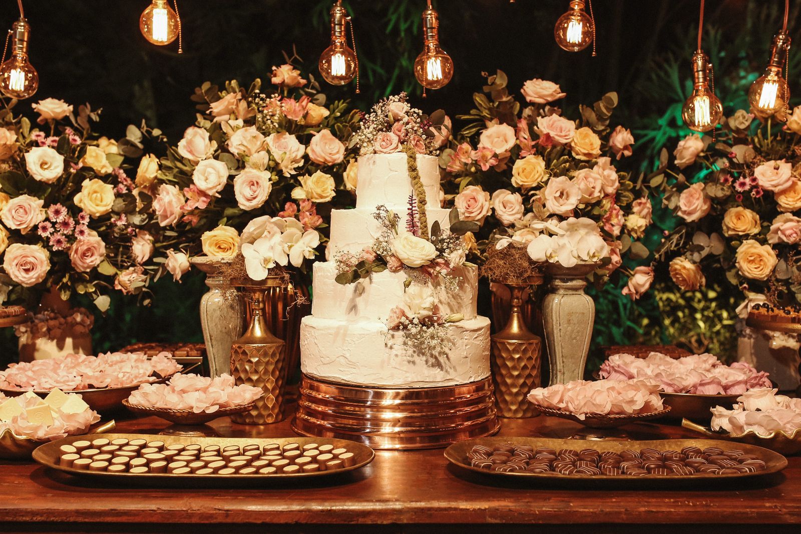 Wedding guests bring their own food — dessert table with wedding cake and flowers
